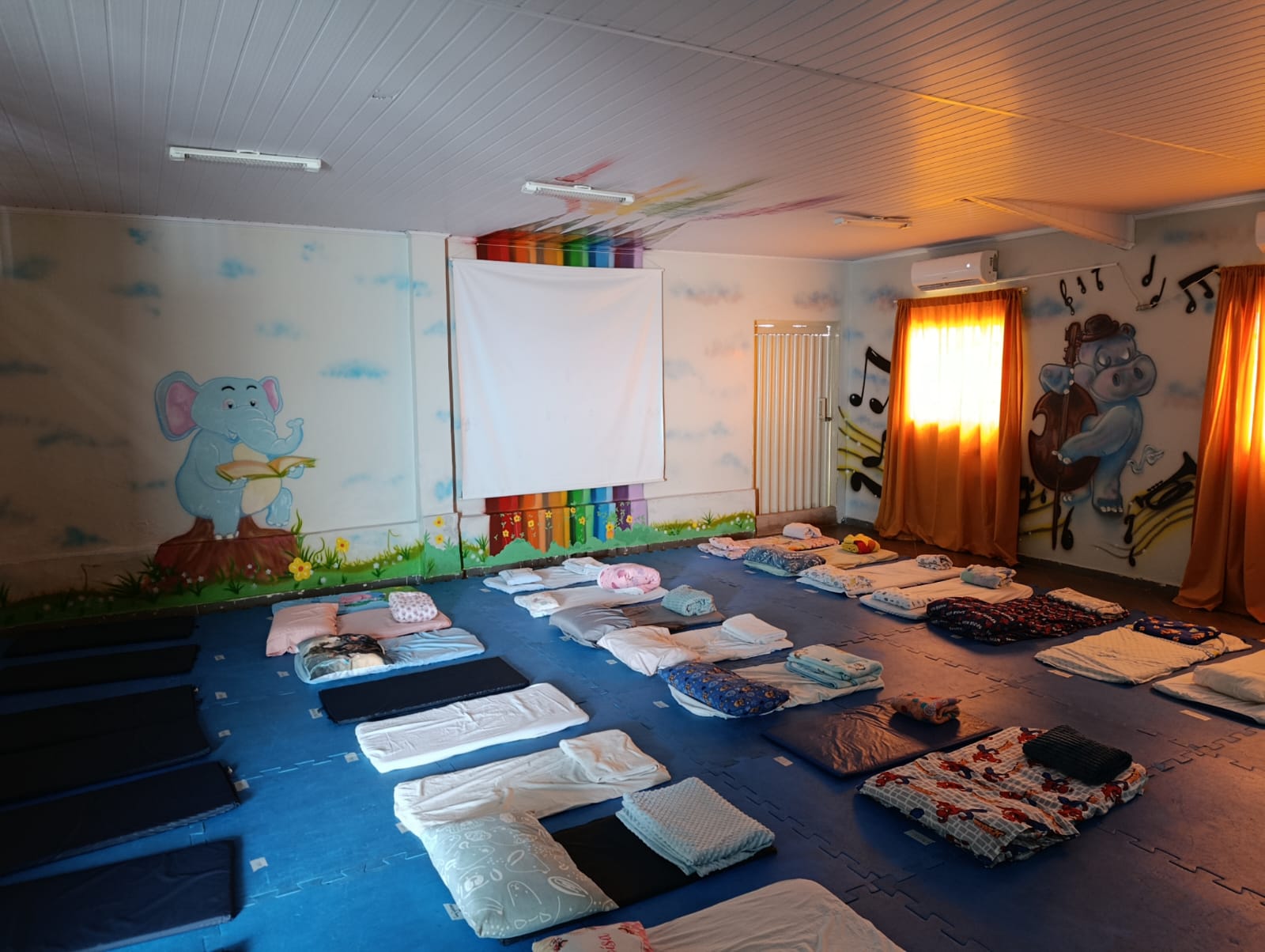 Sala de descanso com colchonetes e lençóis
