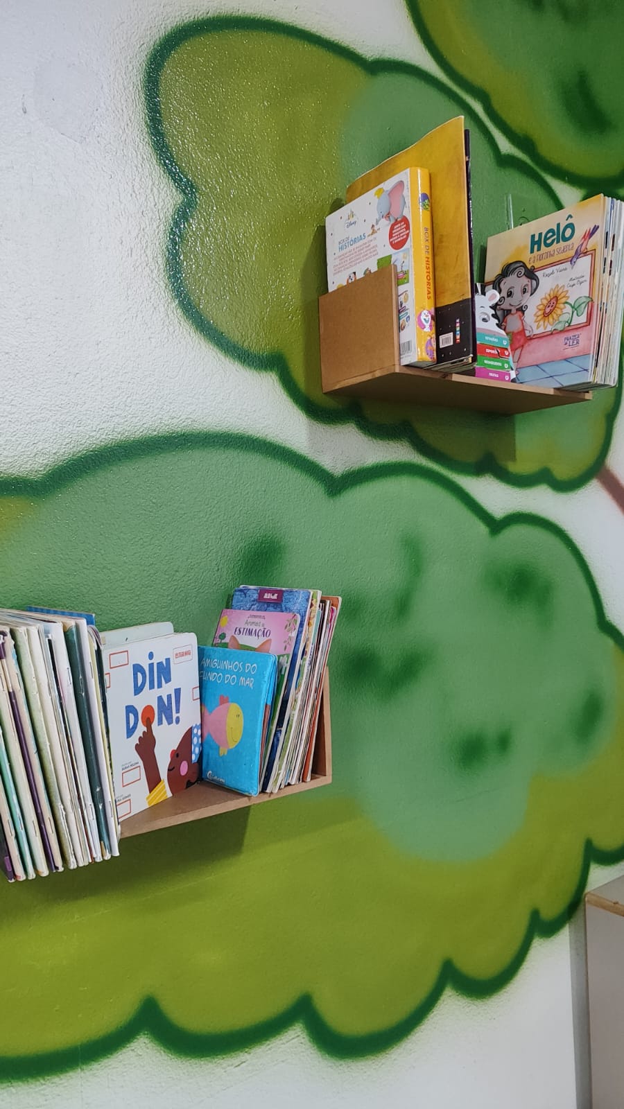 Cantinho de leitura com livros infantis na parede pintada